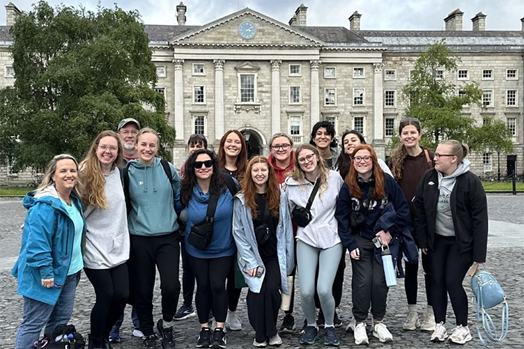 Group of students gather outside of a stone building in Ireland