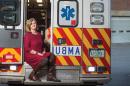 Kristin Duisberg sitting on the back of a McGregor EMS ambulance